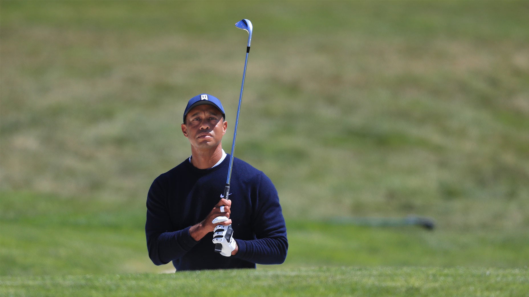 Tiger Woods hits a bunker shot.