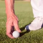 Golfer placing ball