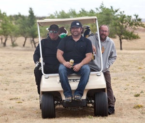 Three golfers in a cart.