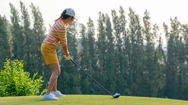 women's golfer hits ball