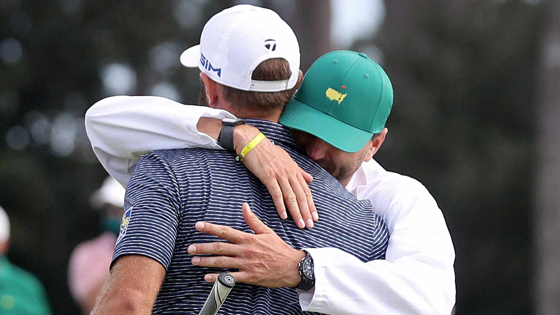 Dustin Johnson and caddie and brother Austin hug.