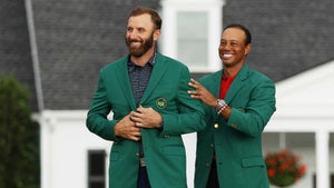Tiger Woods puts the green jacket on Dustin Johnson.