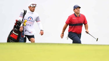 Patrick Reed and his caddie walk up to the green.