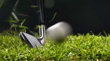 Golf iron hitting golf ball