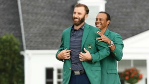 Tiger Woods puts the green jacket on Dustin Johnson.