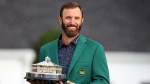 dustin johnson smiles with trophy