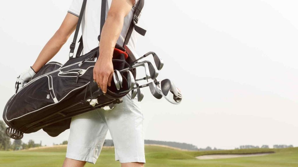golfer carrying clubs