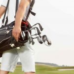 golfer carrying clubs