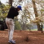 Rory McIlroy hits a ball out of the pinestraw.