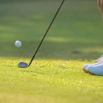 a woman chipping onto a green.