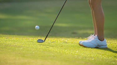 a woman chipping onto a green.
