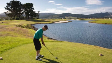 golfer tee shot over water
