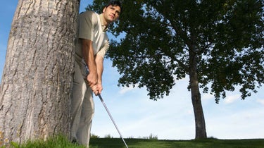 golfer behind tree