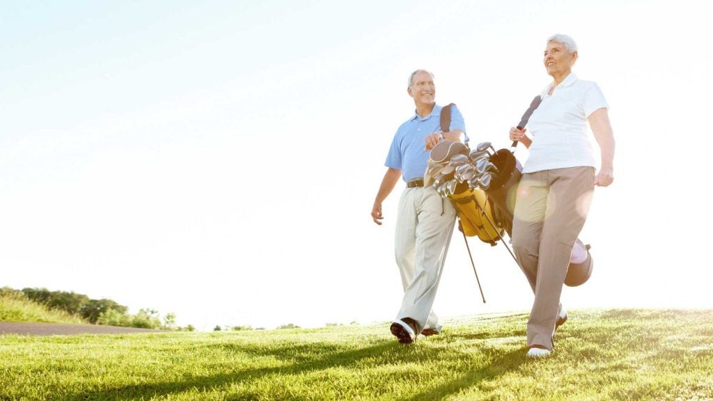 old golfers walk the fairway