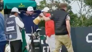 a fan takes a headcover from rory mcilroy's golf bag