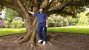 Shane Lowry stands by a tree.