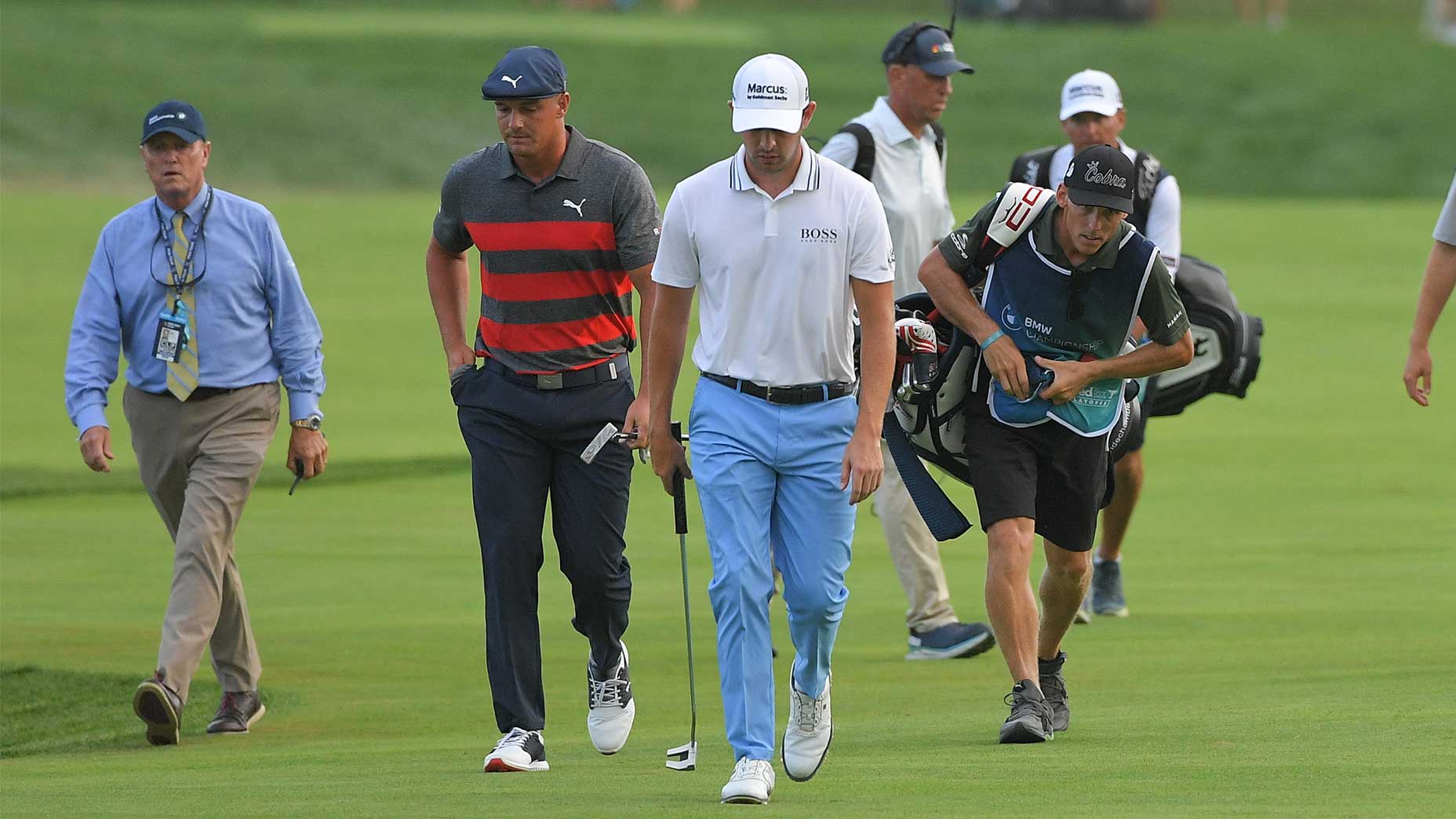 Patrick Cantlay and Bryson DeChambeau walk up the fairway.