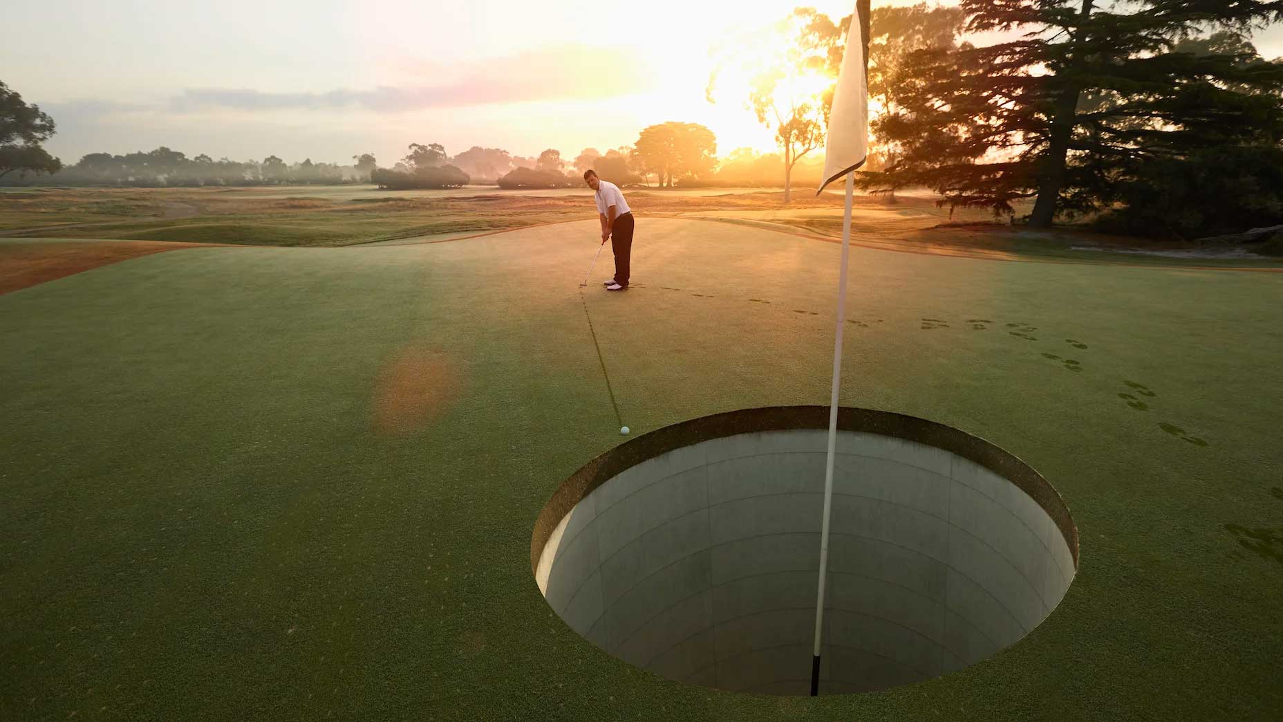 Man putting to giant golf hole