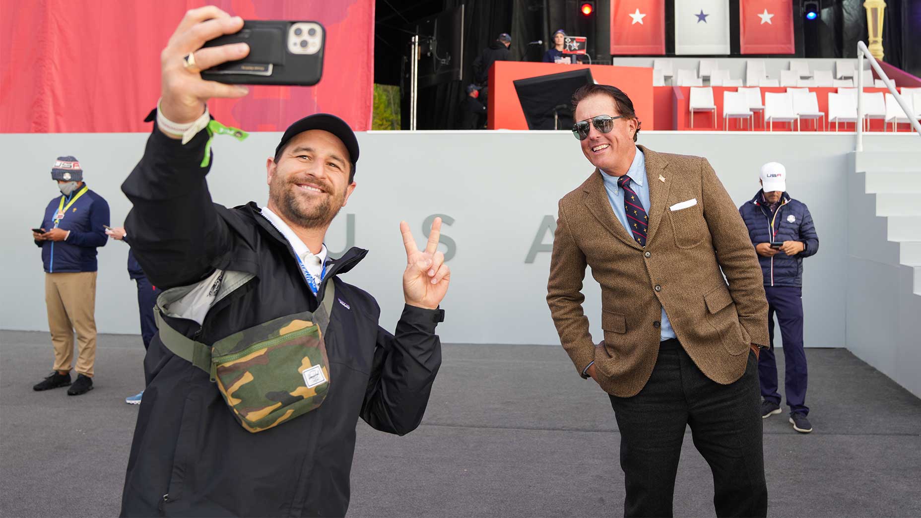 Phil mickelson poses with a photo with a fan.