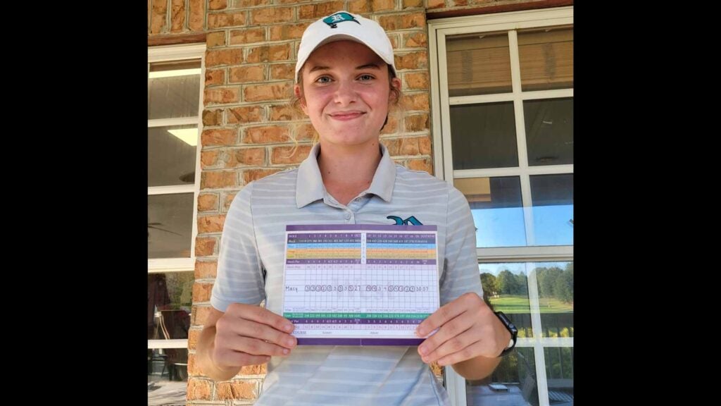High school golfer Macy Pate holds up scorecard for her round of 57