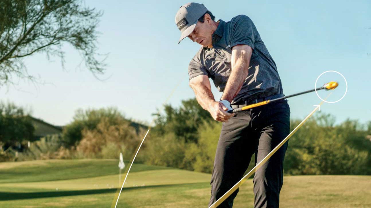 man swings golf training aid