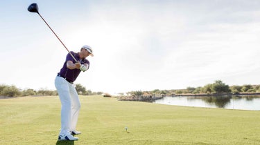 Golfer hitting ball off tee