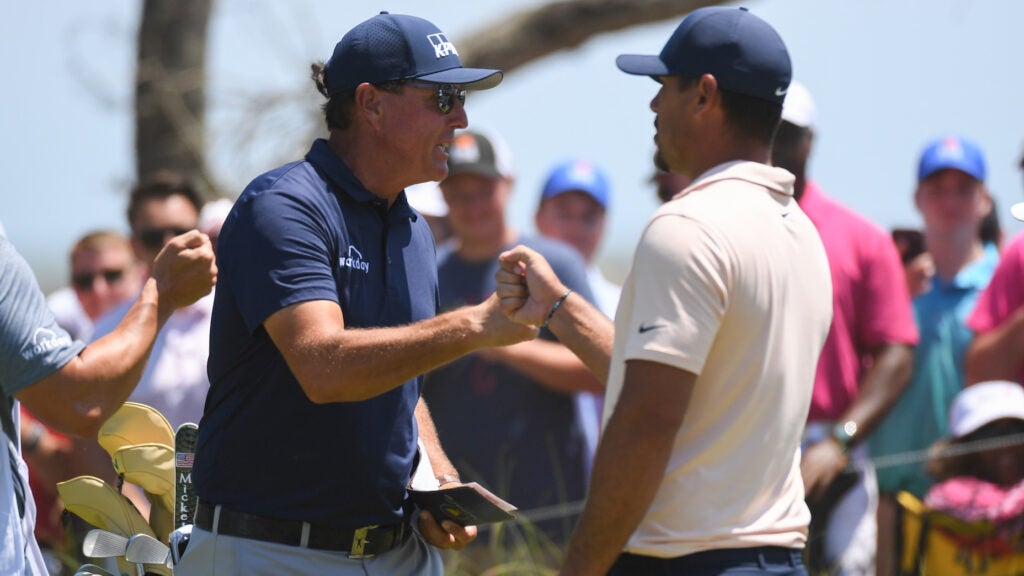 KIAWAH ISLAND, SC - MAY 23: Phil Mickelson fist bumps Brooks Koepka on the first hole during the final round of the 2021 PGA Championship held at the Ocean Course of Kiawah Island Golf Resort on May 23, 2021 in Kiawah Island, South Carolina. (Photo by Montana Pritchard/PGA of America via Getty Images)