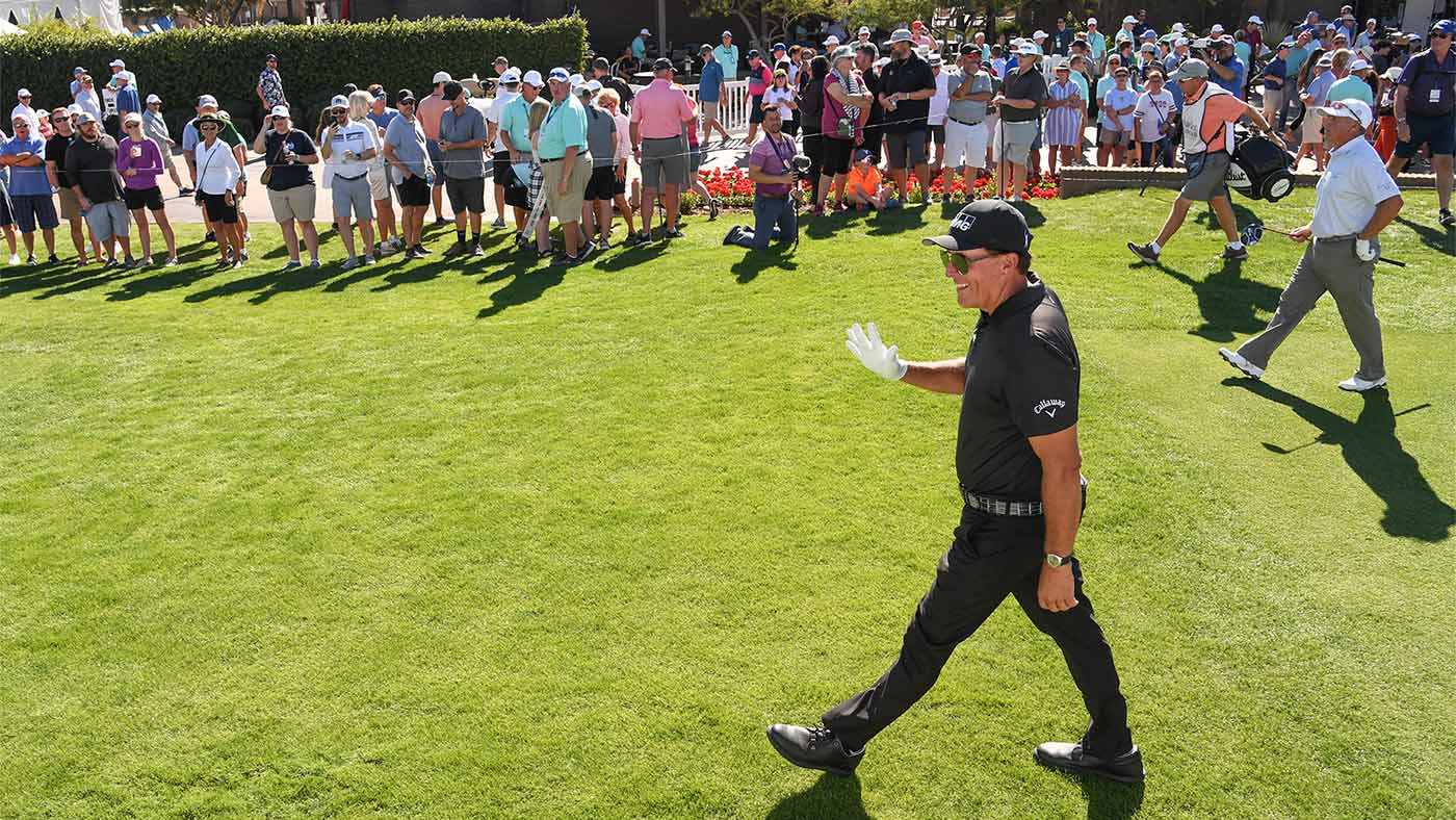 phil mickelson walks and waves to the fans in phoenix.