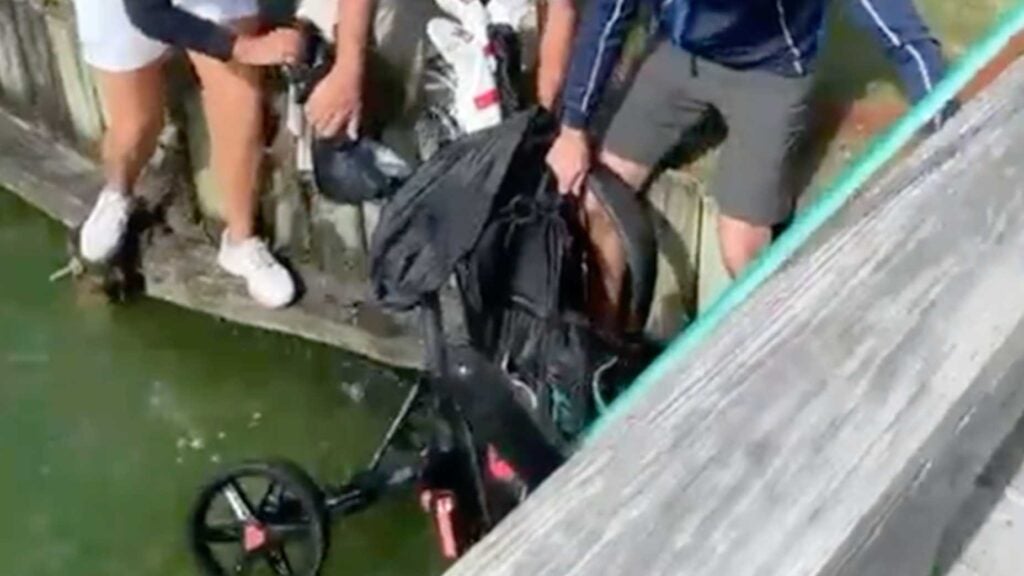 a golfer's push cart falls in the water