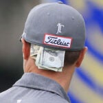 money tucked in back of justin thomas' hat