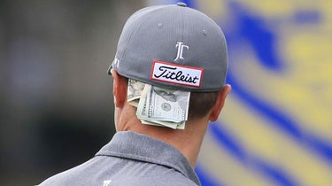 money tucked in the back of justin thomas' hat