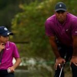 Tiger Woods and Charlie Woods read putt on golf green at PNC Championship