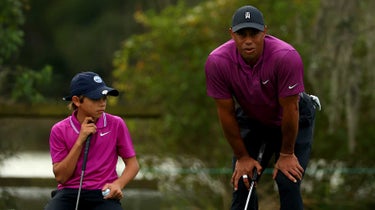 Tiger Woods and Charlie Woods read putt on golf green at PNC Championship
