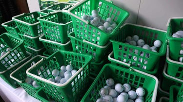driving range balls sitting in baskets at a range