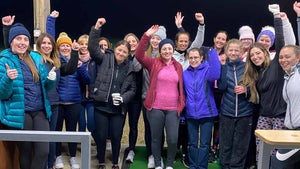 women in a group at a driving range