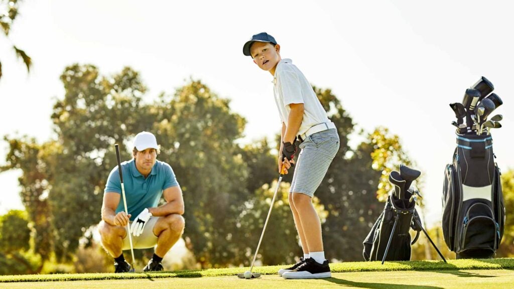 man and junior golfer