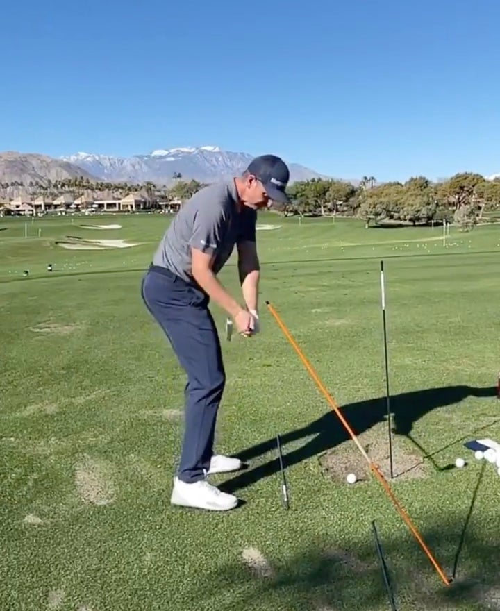 Why do so many pro golfers swing with a stick in the ground on the range?