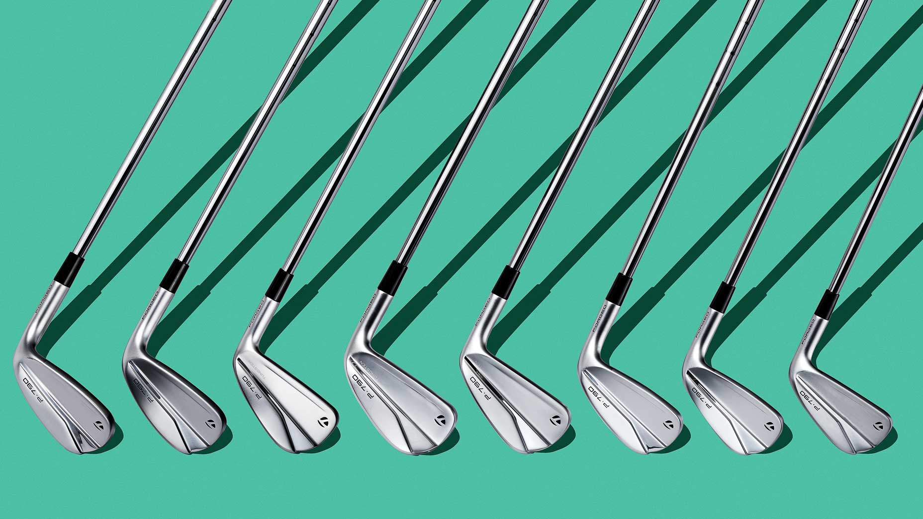 TaylorMade P790 golf irons laid out on a blue background