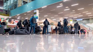Travelers await for their bags at an airport.