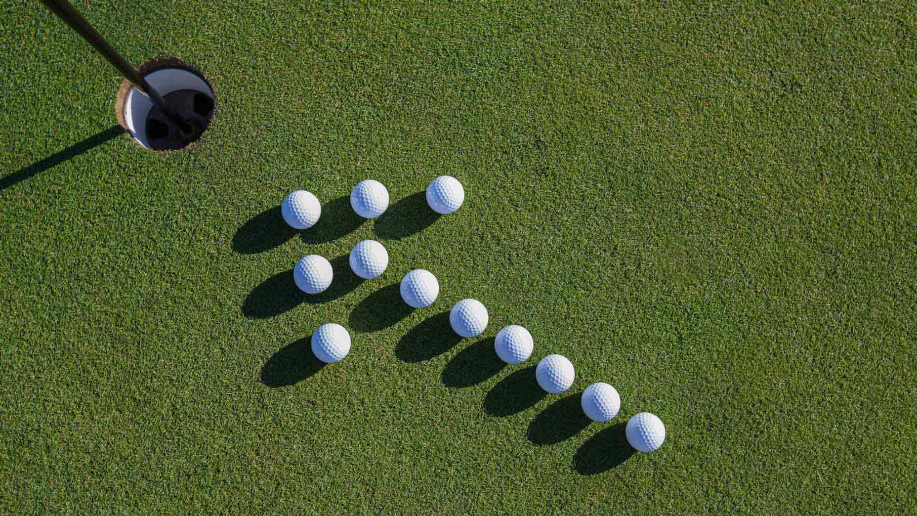 golf balls in arrow formation on green