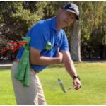 Golf instructor demonstrates drill with towel