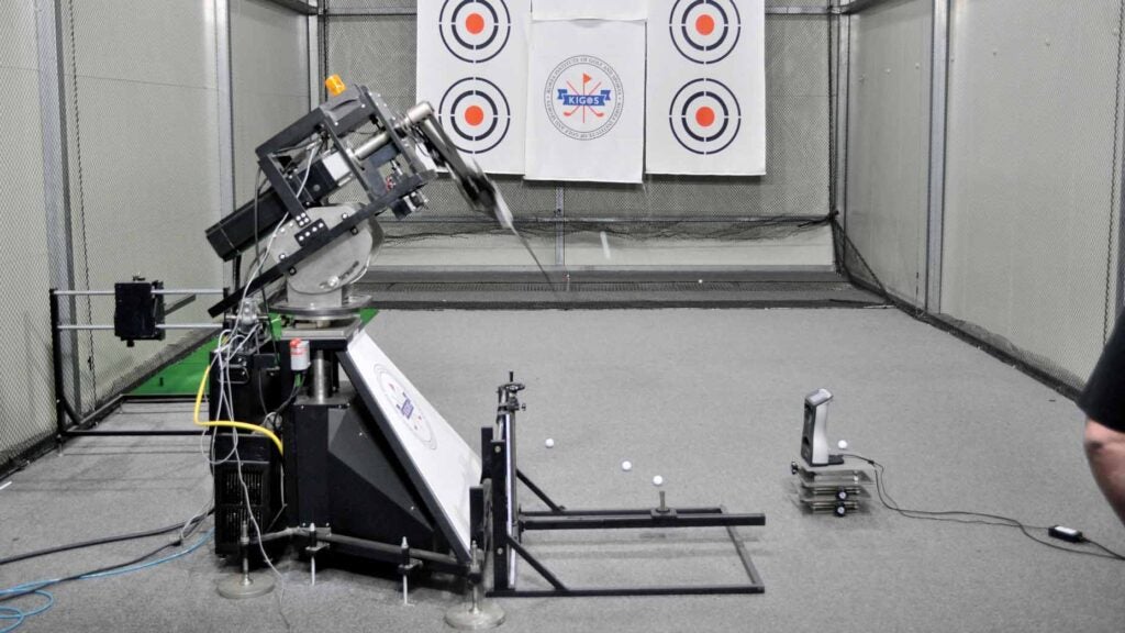 A golf swing robot testing golf clubs in a lab