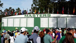 Fans stand in front of empty Masters leaderboard at Augusta National
