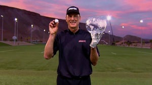 man holds trophy and golf ball