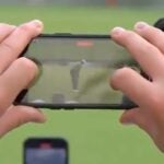 An ESPN camera gets a shot of a Tiger Woods putt through the phone of a fan.