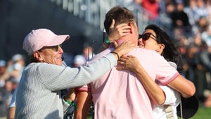 Justin Thomas of the United States hugs his mother Jani Thomas and his fiance Jillian Wisniewski after his winning putt on the 18th hole, the third playoff hole during the final round of the 2022 PGA Championship at Southern Hills Country Club on May 22, 2022 in Tulsa, Oklahoma