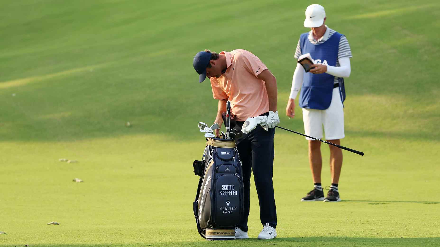 Scottie Scheffler looks in his golf bag at the PGA.
