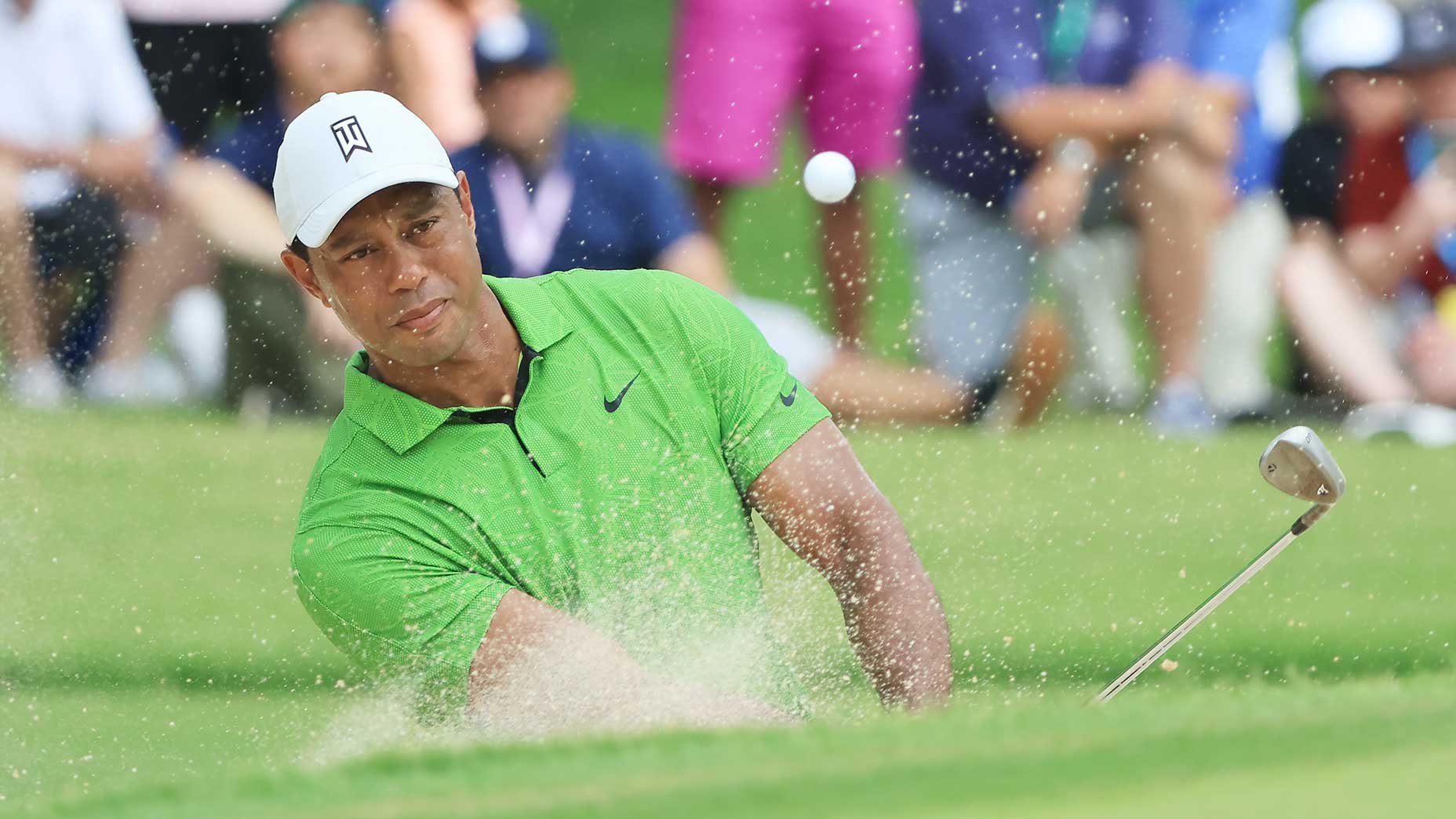 Tiger Woods blasts out of a bunker on Friday at Southern Hills.