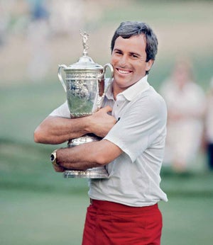 American golfer Curtis Strange hugs the trophy after winning the first of his two consecutive victories in the US Open