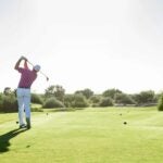 Golfer teeing off on golf course